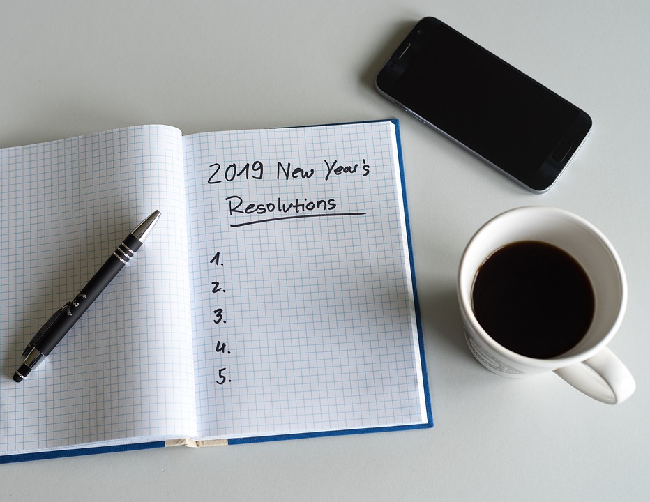 A pad of paper with “2019 New Year’s Resolutions” written at the top of a blank numbered list