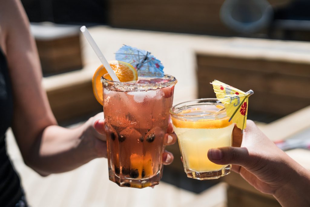 Two people toasting with summer cocktails
